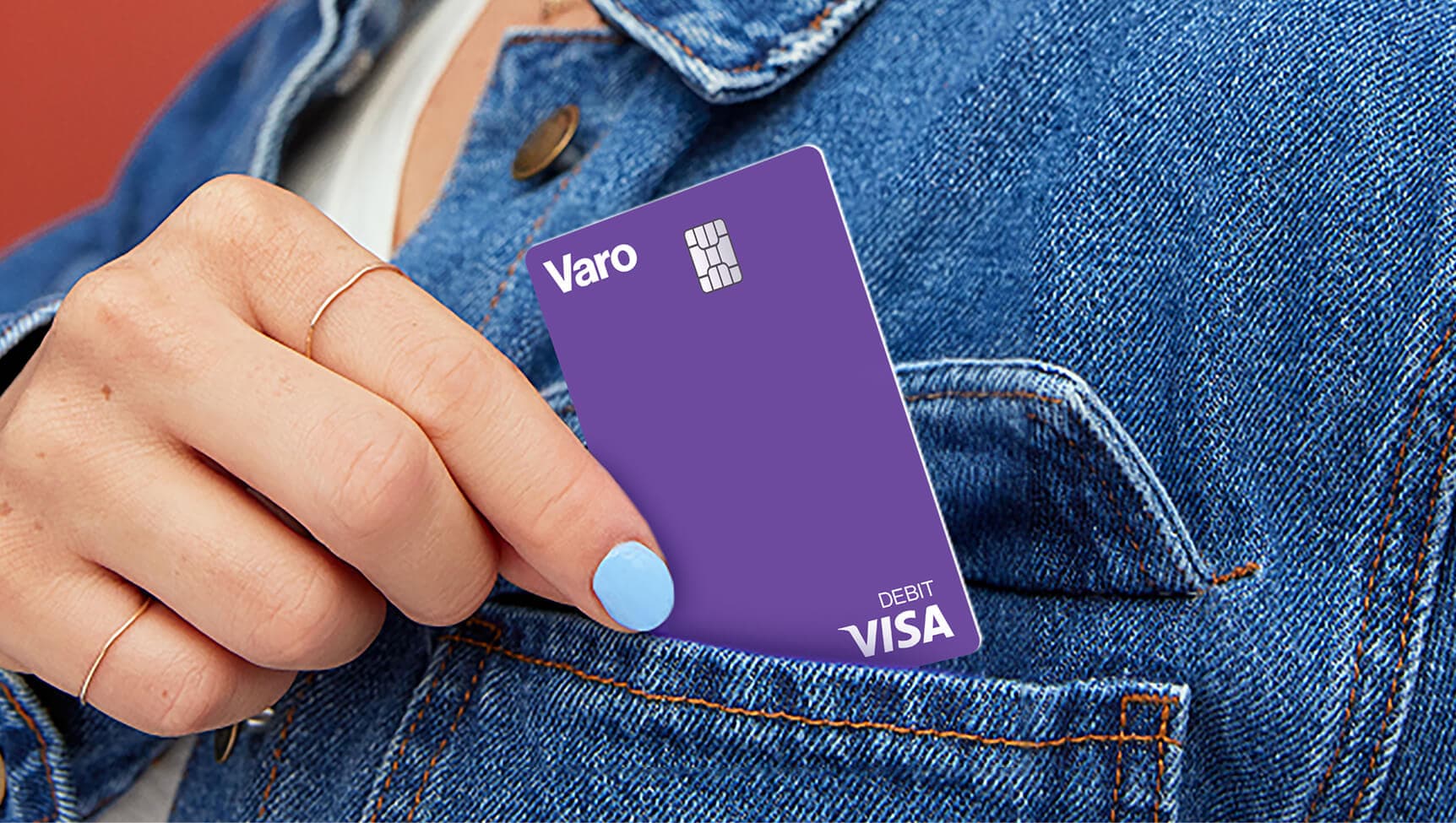 woman putting purple varo debit card into jean jacket pocket no face
